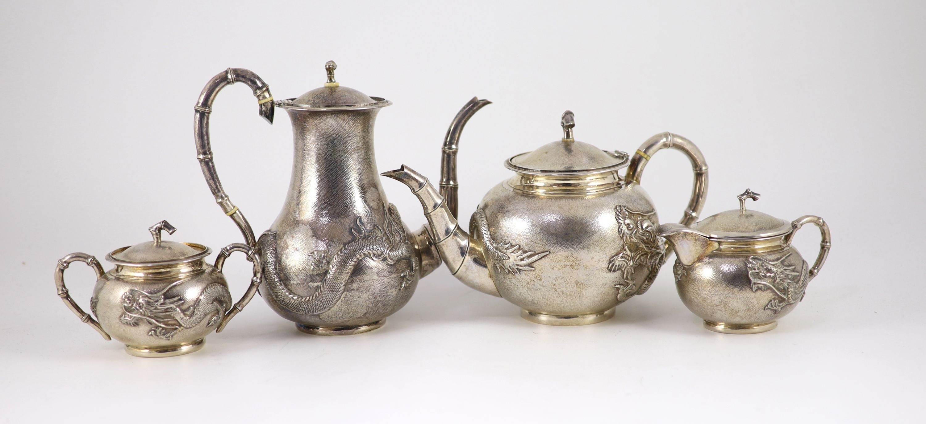 A matched early 20th century Chinese four piece planished silver tea and coffee set, cream and sugar by Wang Hing, teapot by Tack Hing and coffee pot apparently unmarked